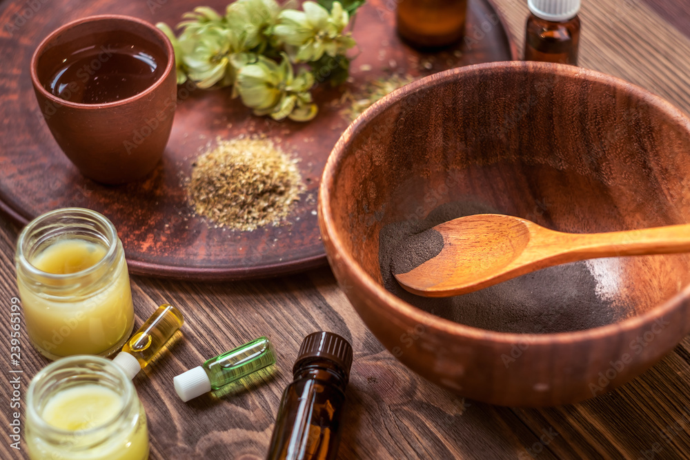 Preparing homemade mask with clay. A lot of ingredients for home made cosmetics in background Preparing homemade mask with clay. A lot of ingredients for home made cosmetics in background
