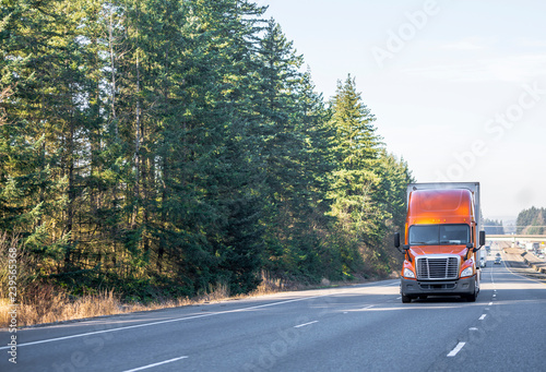 Wallpaper Mural Front view of big rig orange semi truck with semi trailer driving up the hill on wide multiline highway Torontodigital.ca