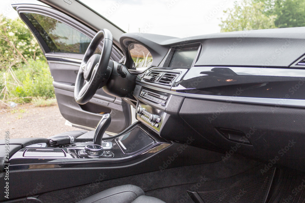 Modern car interior, steering wheel and dashboard, car navigation, automatic transmission shift selector, car climate control, comfortable vehicle Modern car interior, steering wheel and dashboard, car navigation, automatic transmission shift selector, car climate control, comfortable vehicle