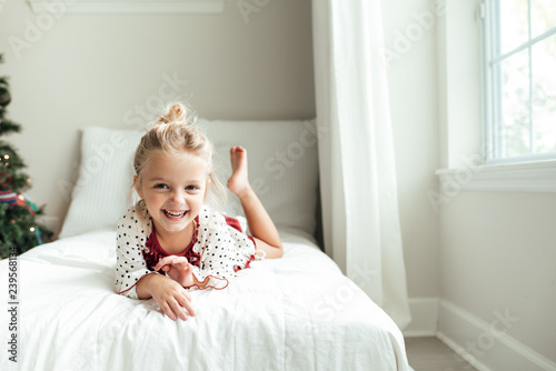 Smiling young girl lying on a bed
