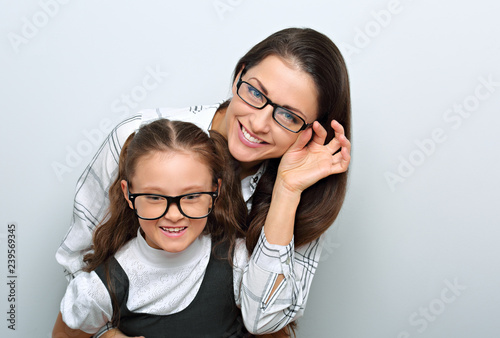 Happy young mother and lauging kid in fashion eye glasses hugging