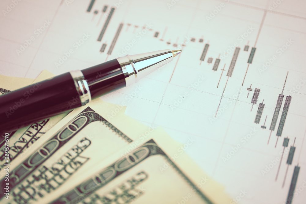 Concept of currency market analysis. Pen on a graph with us dollars. Toned. Concept of currency market analysis. Pen on a graph with us dollars. Toned.