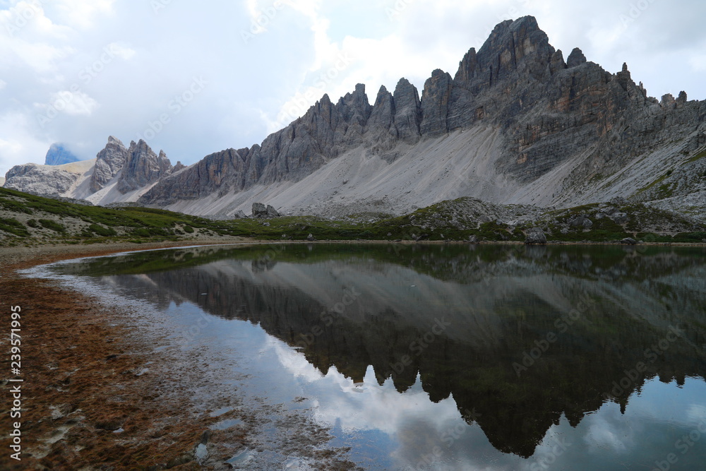 Dolomite Alp mountain near the lakewith reflection in Italy