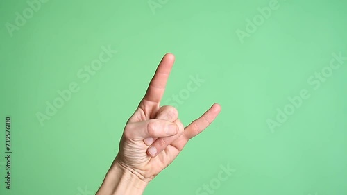 Hands gesturing heavy metal rock sign isolated green screen
