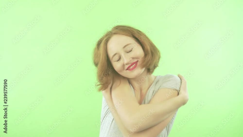 Beautiful young red-head woman isolated on green background. Hugging oneself happy and positive, smiling confident. Self love and care. Beautiful young red-head woman isolated on green background. Hugging oneself happy and positive, smiling confident. Self love and care.
