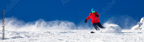 Człowiek na nartach na przygotowanym stoku ze świeżym, nowym śniegiem