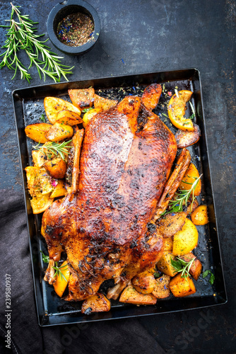 Traditional American roasted Thanksgiving turkey with fruits and potatoes as top view on a board