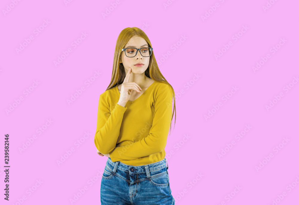 The girl with long red hair in glasses conceived looks to side on an isolated background The girl with long red hair in glasses conceived looks to side on an isolated background