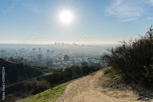 Los Angeles Runyon Canyon Park hiking trail with morning sun, downtown and Hollywood in background.