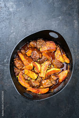 Traditional Iranian khoresh beh stew with chunks of lamb and quinces as top view in a modern style Japanese cast-iron roasting dish