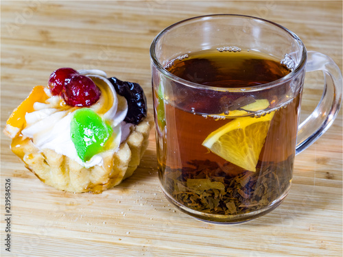 Black tea in a glass tea Cup, Shortbread, lemon, waffles, cakes baskets