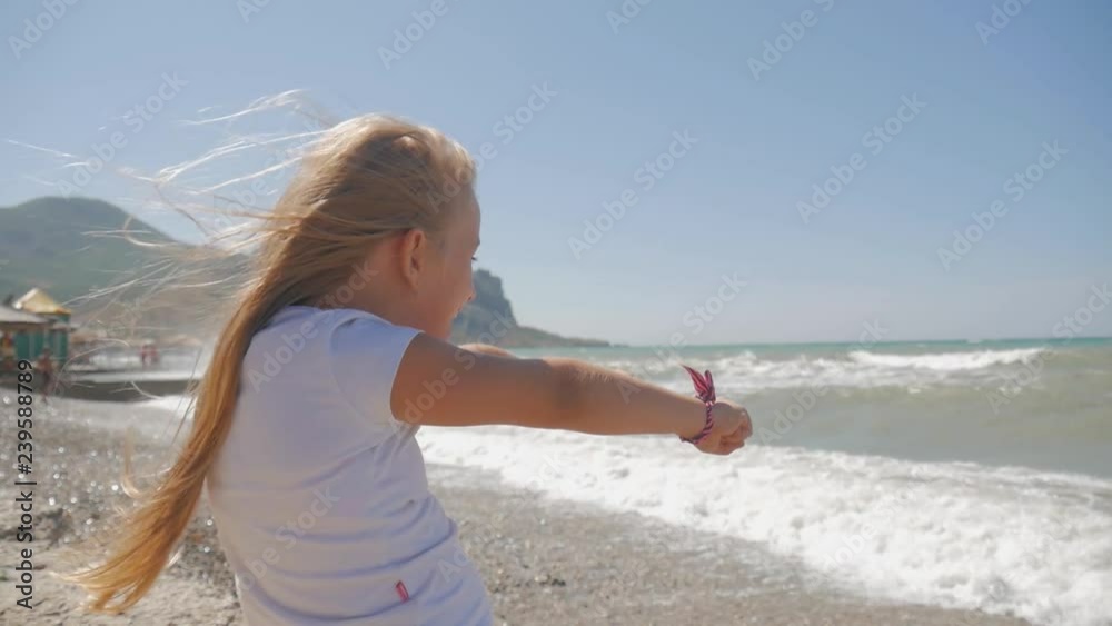 Little girl happily playing with waves at the beach. Little girl happily playing with waves at the beach.
