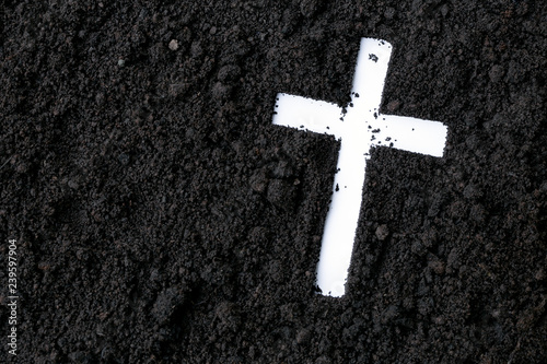 Cross or crucifix made of ash, dust or sand. Ash Wednesday. Lent. Christian religion.