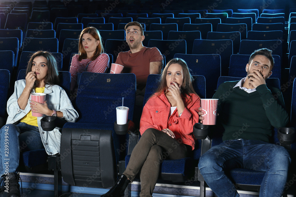 Naklejka premium Young people watching movie in cinema theatre