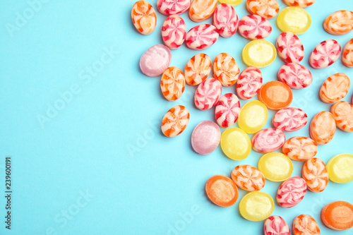 Flat lay composition with delicious colorful candies and space for text on color background