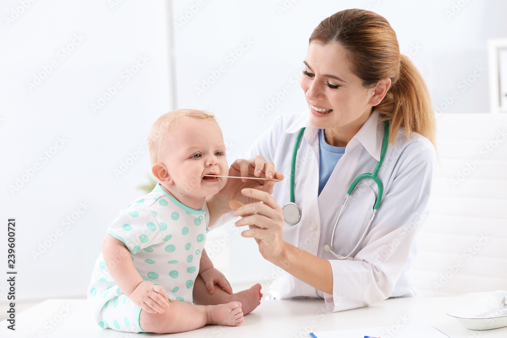 Children's doctor examining baby's throat in hospital Children's doctor examining baby's throat in hospital