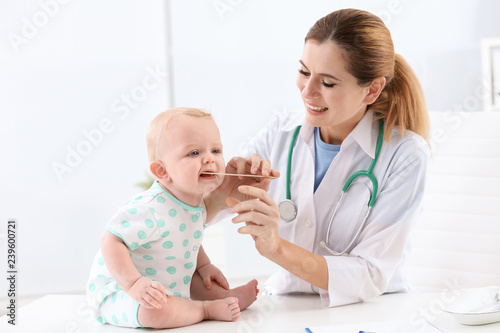 Children's doctor examining baby's throat in hospital