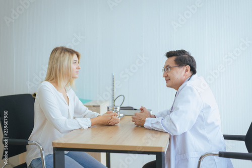 Man doctor examining to woman patient and follow up treatment at hospital