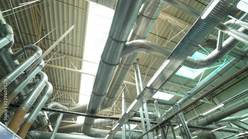 Pipes of the ventilation system are located on the ceiling of plant with the production of parquet. Camera motion to left Pipes of the ventilation system are located on the ceiling of plant with the production of parquet. Camera motion to left