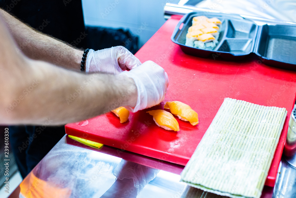 Japanese chef is neatly cutting on fine part of yellow fine tuna to make nigiri maguro sushi Japanese chef is neatly cutting on fine part of yellow fine tuna to make nigiri maguro sushi