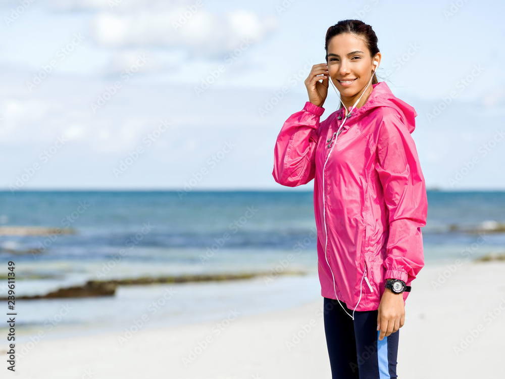 Sporty woman with earphones on the sea coast Sporty woman with earphones on the sea coast