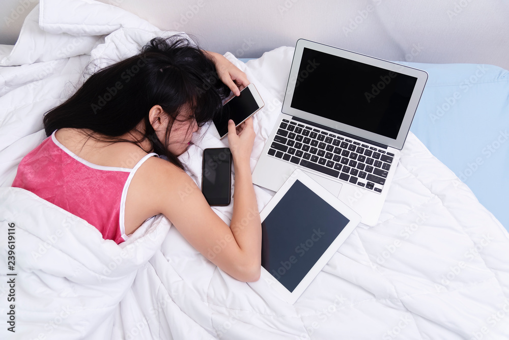 Hard work or hard play in technology. Tired young woman sleeping whille using technology devices. Hard work or hard play in technology. Tired young woman sleeping whille using technology devices.