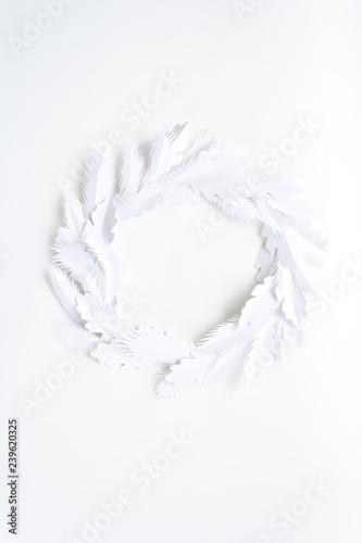 Christmas wreath made of white paper on white background