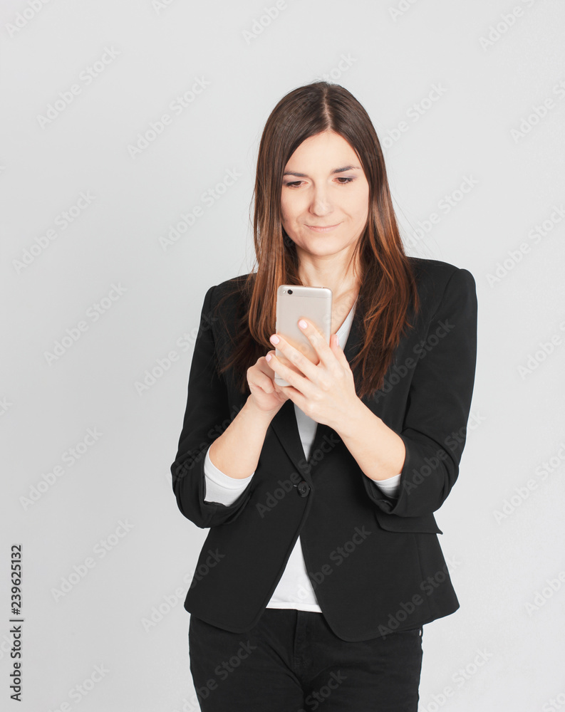 Young smiling brunette woman lady in business suit typing a mess Young smiling brunette woman lady in business suit typing a mess