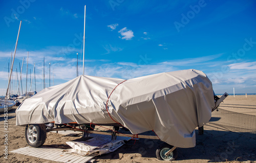 Row of boats in storage for frost under awning. Warehouse on boat pier. preparation winter.