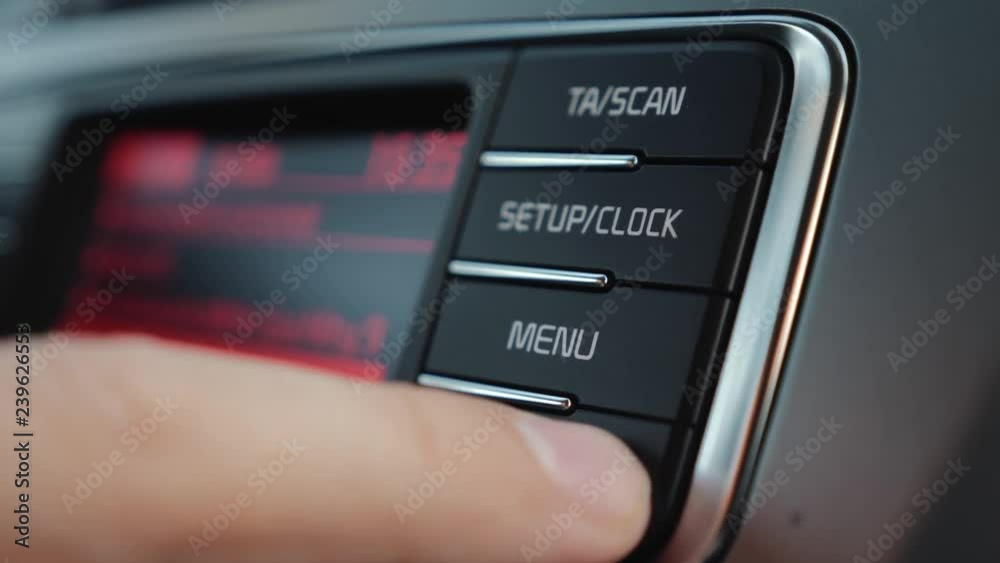 A person using a car audio system adjusts the volume and frequency A person using a car audio system adjusts the volume and frequency