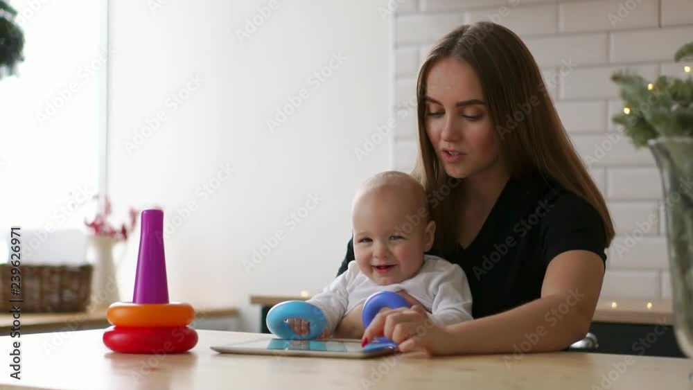Cute 10 months old baby boy playing on floor with colorful toys Cute 10 months old baby boy playing on floor with colorful toys