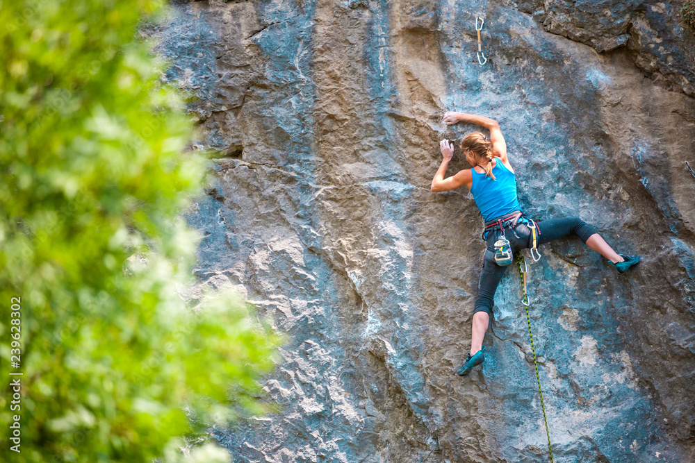 A woman climbs the rock.