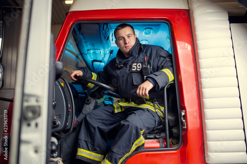 Photo of fireman man sitting in fire truck