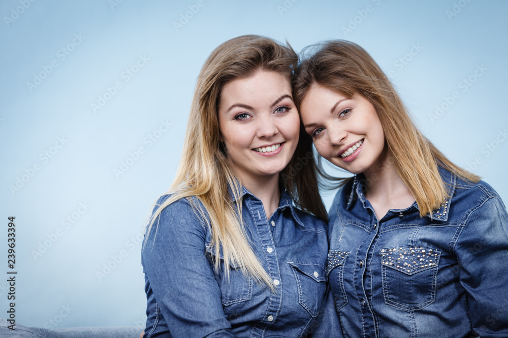Fototapeta premium Two happy women friends wearing jeans outfit