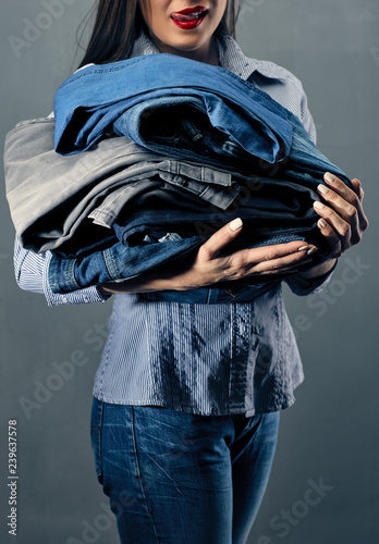 woman holding heap of clothes.
