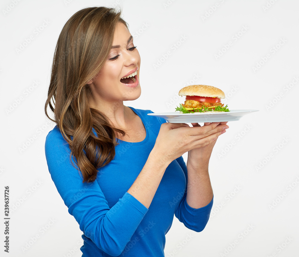 smiling woman holding plate with hamburger.