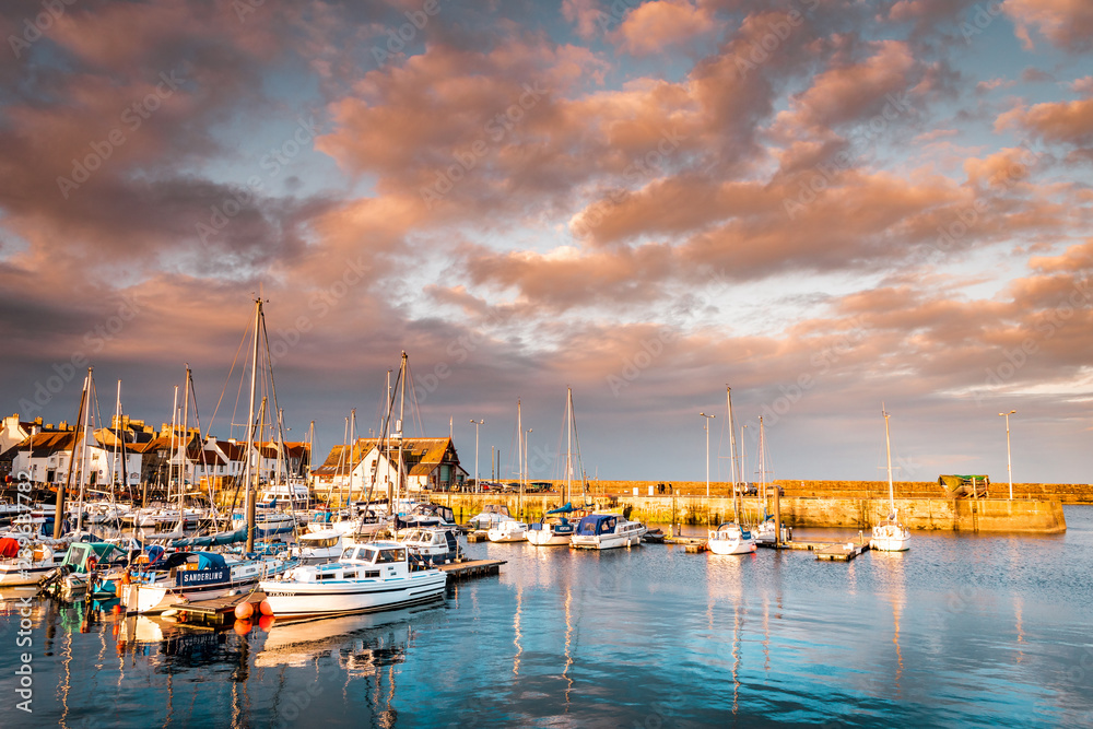 Vacation in Scotland with picturesque sunset in the small fishing village Anstruther on the Scottish east coast, not far from St. Andrews, the small fishing boats in the marina are perfect for relaxin