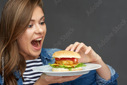 Woman holding burger on white plate