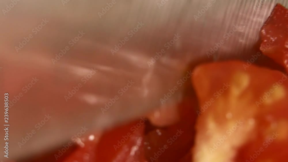 Macro shooting. Closeup of tomatoes cut into small pieces. Tomatoes cut with a large knife Macro shooting. Closeup of tomatoes cut into small pieces. Tomatoes cut with a large knife