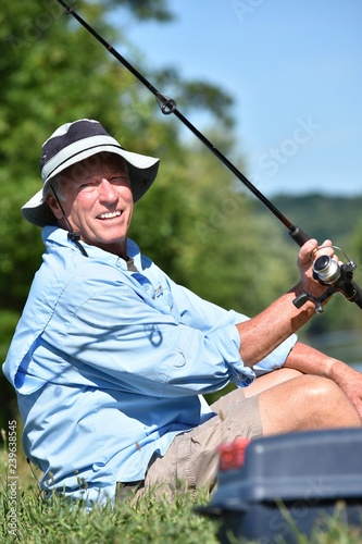 Happy Senior Sportsman With Fishing Rod Outdoors