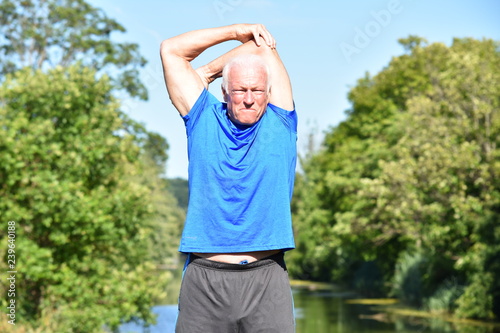 Athletic Male Senior Stretching By River © dtiberio
