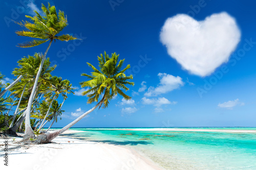Fototapeta Naklejka Na Ścianę i Meble -  romantic getaway concept - tropical beach with palm trees and heart shaped cloud in french polynesia