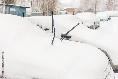 The car, covered with thick layer of snow. Negative consequence of heavy snowfalls. parked cars covered with snow during snowing in winter time