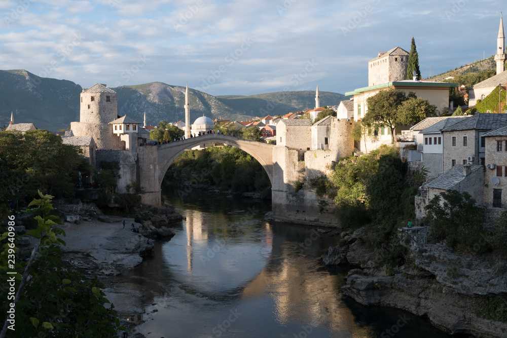 Day time view of the city of Mostar's  along the river, featuring the rebuilt arched bridge: 