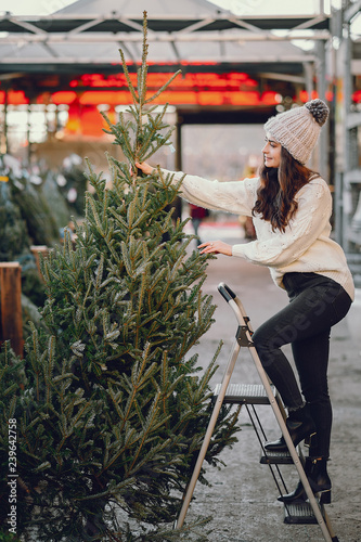 Cute brunette in a white sweater with Christmas tree