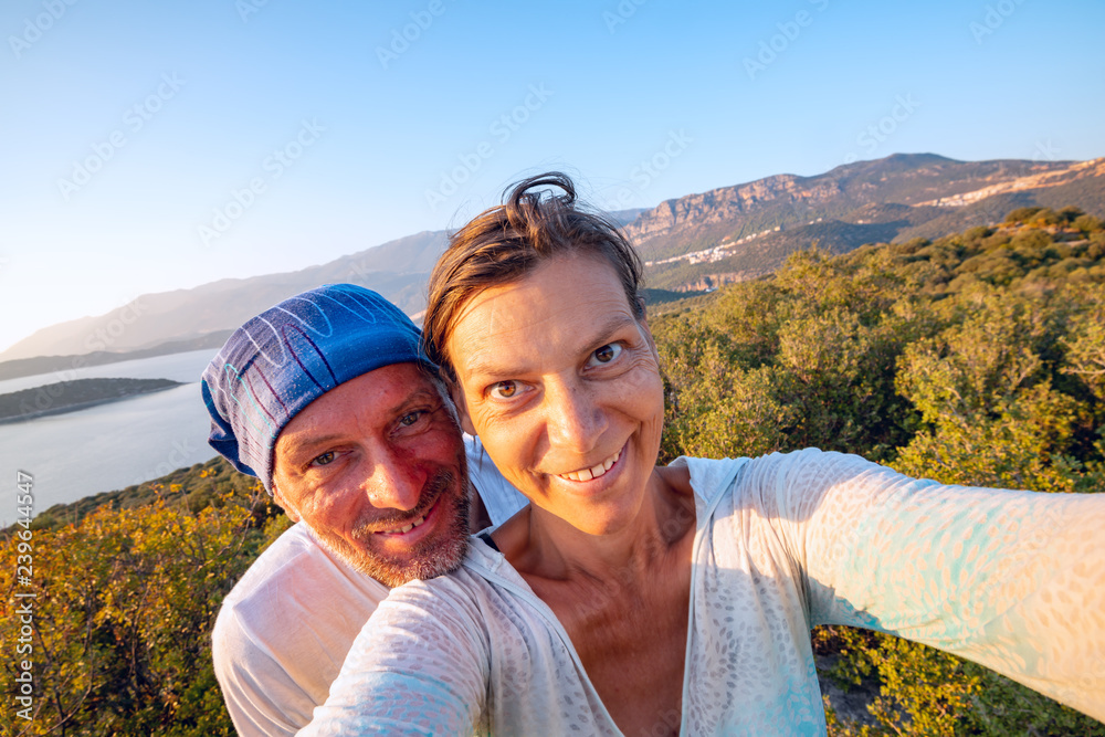 Couple of joyful travelers taking selfie in the mountains