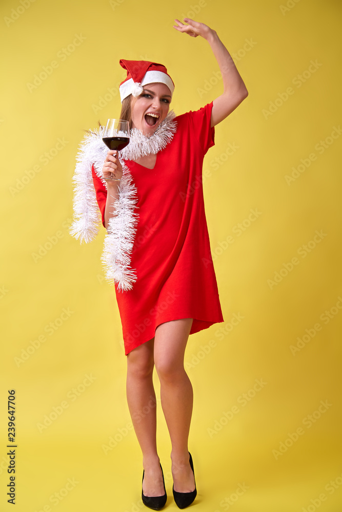 Beautiful happy woman in santa claus hat with glass of wine. Birthday or New Year event celebrating concept