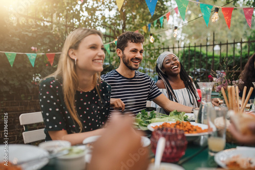 Smiling friends enjoying food during party in backyard