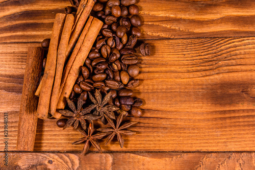 Pile of the coffee beans, star anise and cinnamon sticks on wooden table. Top view