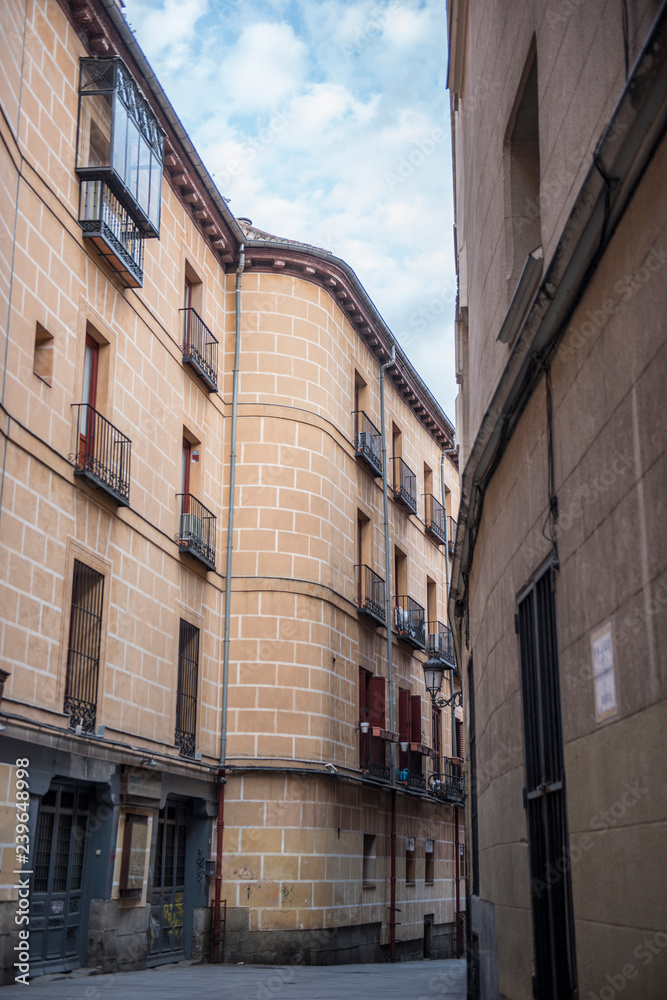Exterior of a local building in Spain. The building seems to be a mix of old and modern architecture. The Streets seem to be narrow. It seems to be a sunny day.